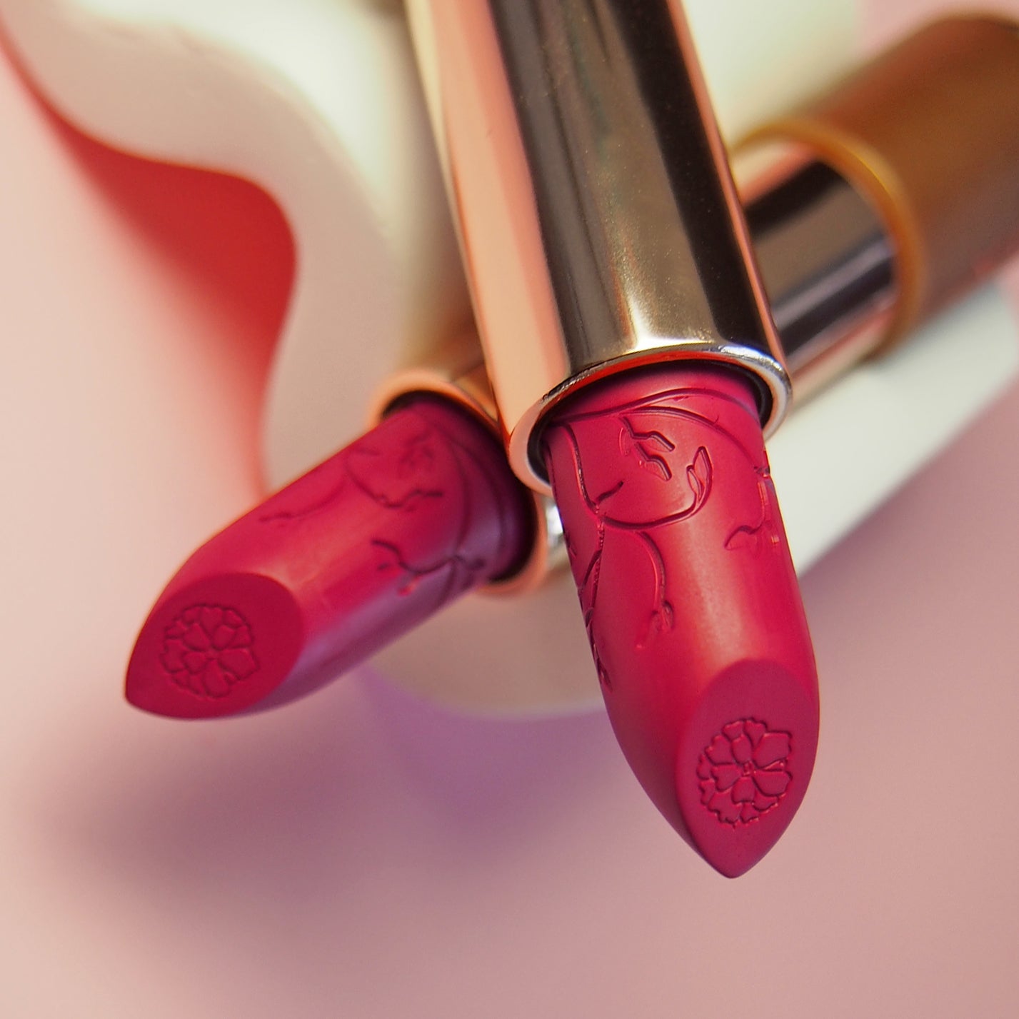 10 Magenta Moon - Natural Lipstick. Two lipsticks crossed over each other 