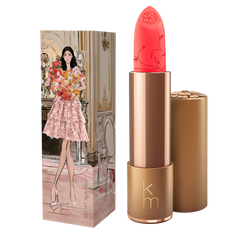 Bright coral coloured lipstick in gold case. box with girl holding a bunch of poppy flowers 