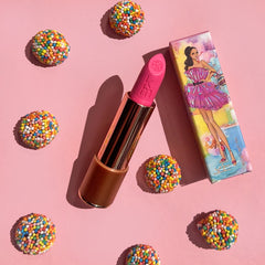 Pink lipstick with box surrounded by candy 