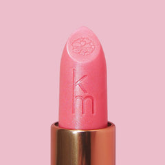 Pink lipstick with gold cap on a pink background