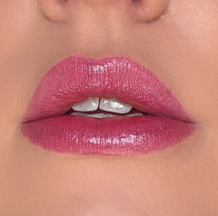 Close-up of a person wearing pink lipstick on a neutral background